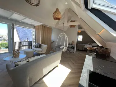 a living room with a couch and a chair at Loft met zeezicht in Egmond aan Zee