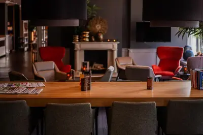 a dining room with a table and red chairs at Golden Tulip Leiden Centre in Leiden