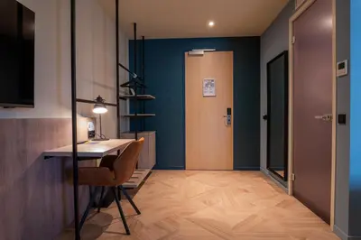 a hallway with a desk and a door to a room at Golden Tulip Leiden Centre in Leiden