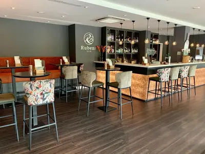 a bar in a restaurant with bar stools at Golden Tulip Leiden Centre in Leiden
