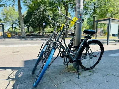 two bikes chained to a pole on a street at Sunshine Suites in Utrecht
