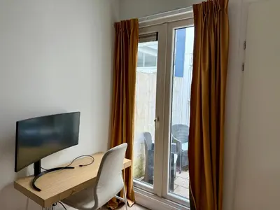 a room with a desk with a television and a window at Sunshine Suites in Utrecht