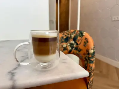 a glass mug of coffee sitting on a table at Sunshine Suites in Utrecht