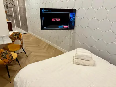 a hospital room with a bed and a tv on the wall at Sunshine Suites in Utrecht
