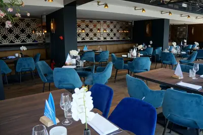 a dining room with blue chairs and tables at Fletcher Hotel Restaurant Loosdrecht-Amsterdam in Loosdrecht