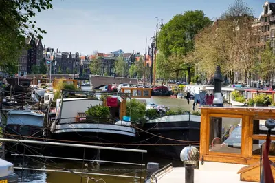 a group of boats docked in a canal at Westerdok25 in Amsterdam