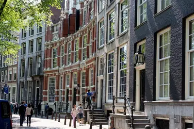 a group of people walking down a street in front of buildings at Westerdok25 in Amsterdam