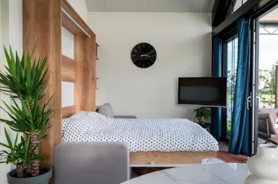 a bedroom with a bed and a clock on the wall at 4 to 6 persons Tulpenacker waterfront in Roelofarendsveen