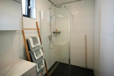 a bathroom with a shower with a glass door at 4 to 6 persons Tulpenacker waterfront in Roelofarendsveen