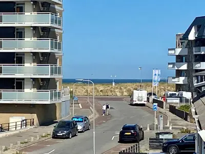 a street with cars parked in front of a building at Glücklich am Meer Meerblick mit Wellnesszugang in Egmond aan Zee