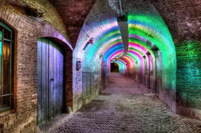 an alleyway with colored lights on the walls at NH Centre Utrecht Hotel in Utrecht