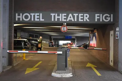 a parking garage with a hotel theater sign and cars at Hotel Theater Figi in Zeist