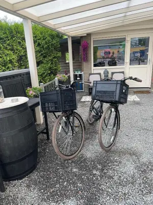 a couple of bikes parked next to a barrel at Casa di maksch de miniatura in Amsterdam