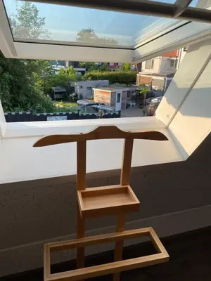 a wooden table in front of a large window at Casa di maksch de miniatura in Amsterdam