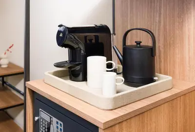 a black coffee maker and cups on a counter at NH Zandvoort Hotel in Zandvoort