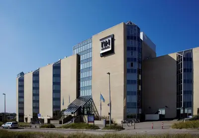 a large building with a sign on the side of it at NH Zandvoort Hotel in Zandvoort