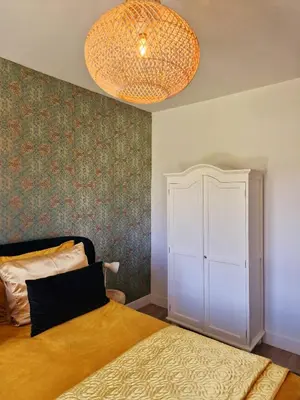 a bedroom with a bed and a chandelier at Studio Flevo Batavia in Lelystad