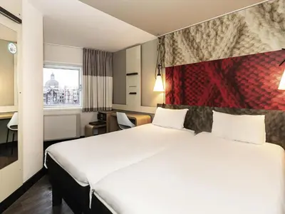 a hotel room with a bed and a window at ibis Amsterdam Centre in Amsterdam