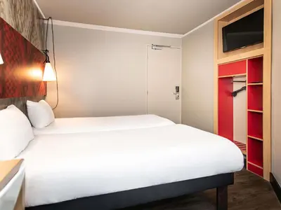 a hotel room with a bed and a tv at ibis Amsterdam Centre in Amsterdam