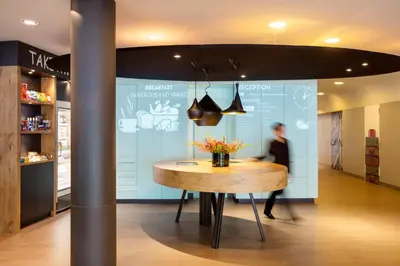 a person walking past a table in a store at ibis Amsterdam Centre Stopera in Amsterdam