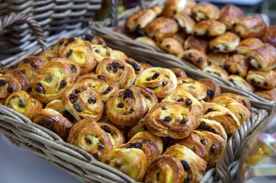 a bunch of pastries in baskets on a table at Holiday Inn Express Amsterdam Arena Towers by IHG in Amsterdam