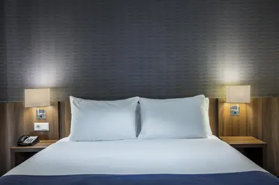 a large bed with two pillows and a telephone at Holiday Inn Express Amsterdam Arena Towers by IHG in Amsterdam