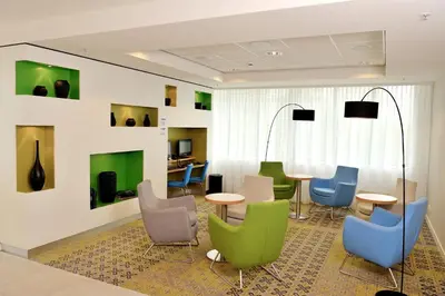 a waiting room with colorful chairs and tables at Holiday Inn Express Amsterdam Arena Towers by IHG in Amsterdam