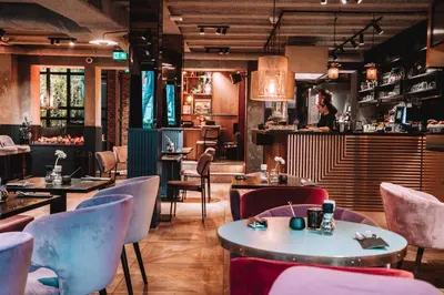 a restaurant with tables and chairs and a waitress at The Highlander Amsterdam in Amsterdam