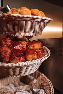 two baskets filled with bread and croissants at The Highlander Amsterdam in Amsterdam