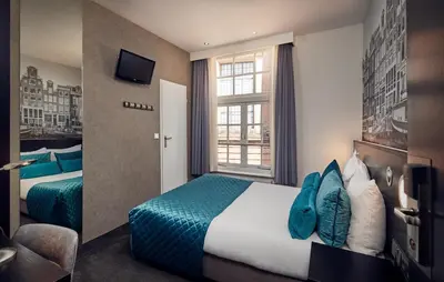 a hotel room with two beds and a window at Singel Hotel Amsterdam in Amsterdam