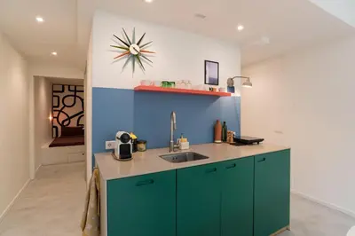 a kitchen with green cabinets and a blue wall at Studio in creative district, FREE parking in Amsterdam