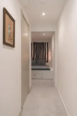 a white hallway with a bed in a bedroom at Studio in creative district, FREE parking in Amsterdam