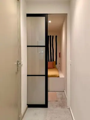 a sliding glass door in a room with a bed at Studio in creative district, FREE parking in Amsterdam