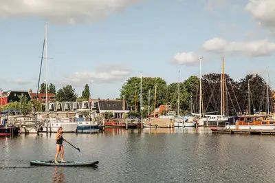 a woman on a paddle board in a marina at Studio in creative district, FREE parking in Amsterdam