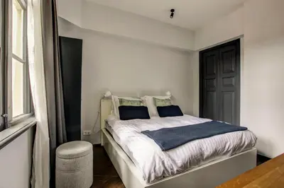 a bedroom with a bed with white sheets and a window at Canal House with Garden in Amsterdam