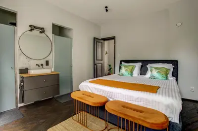a bedroom with a bed and a sink and a mirror at Canal House with Garden in Amsterdam