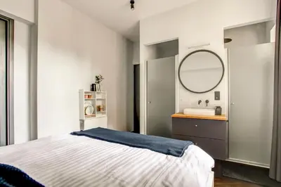 a bedroom with a bed and a sink and a mirror at Canal House with Garden in Amsterdam
