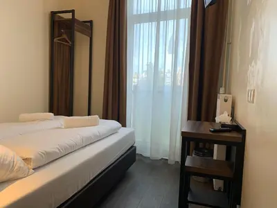a hotel room with a bed and a table and a window at Orange Tulip Hotel in Amsterdam