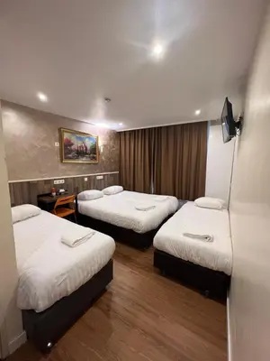 a hotel room with three beds in it at Orange Tulip Hotel in Amsterdam