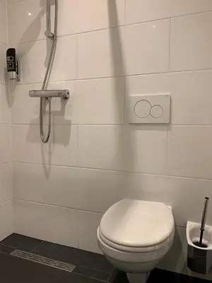 a bathroom with a toilet and a shower at Orange Tulip Hotel in Amsterdam
