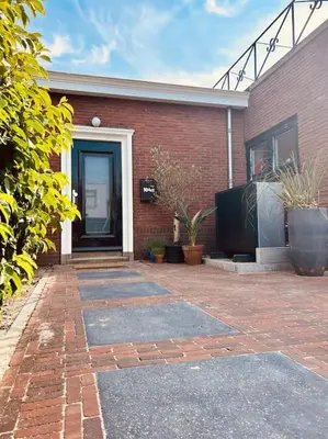 a brick building with a door and a brick patio at The Bank's Lodge by ZILT in Limmen