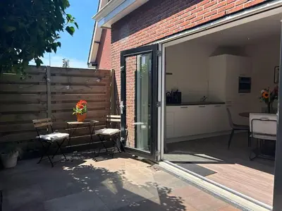 a sliding glass door with a table and chairs on a patio at The Bank's Lodge by ZILT in Limmen