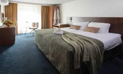 a hotel room with a bed with a teddy bear on it at Hampshire Hotel Petit Nord in Hoorn
