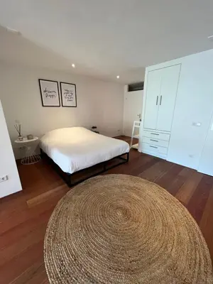 a bedroom with a bed and a large rug at Studio J. in Egmond aan Zee
