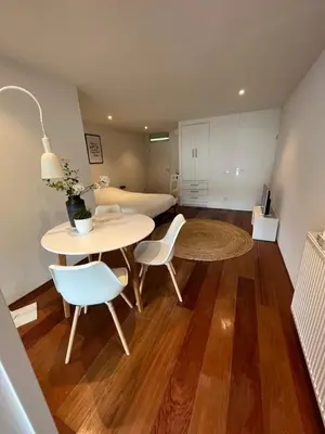 a living room with a table and chairs and a bed at Studio J. in Egmond aan Zee
