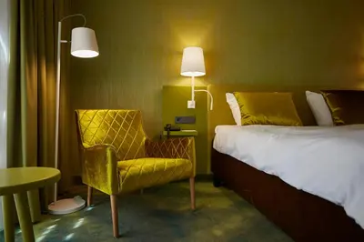 a hotel room with a bed and a chair and a table at Carlton President in Utrecht