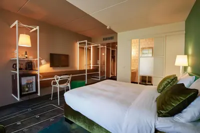 a hotel room with a large bed and a television at Carlton President in Utrecht
