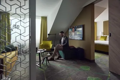 a man sitting in a chair in a hotel room at Carlton President in Utrecht