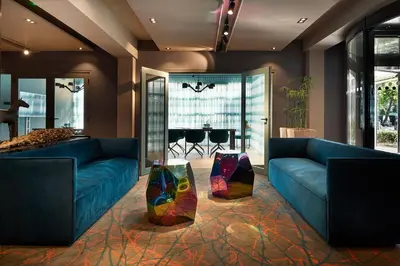 a living room with two blue couches and a table at Carlton President in Utrecht