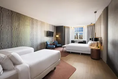 a hotel room with two beds and a couch at NH Collection Amsterdam Flower Market in Amsterdam